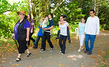 A group of adults and children walk along a trail in a CRD regional park.