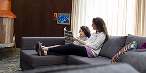Home Energy Navigator program: A family reads on the couch in their home.
